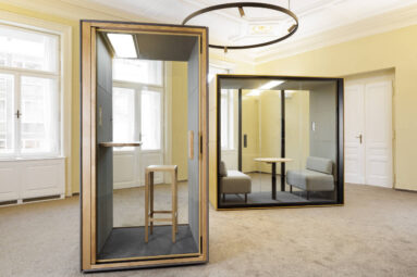 2 Besprechungsboxen. Die erste Box ist für 1 Person mit Steharbeitsplatz, die zweite Besprechungsbox hat zwei kleine Sitzbänke unt einem Tisch in der Mitte.